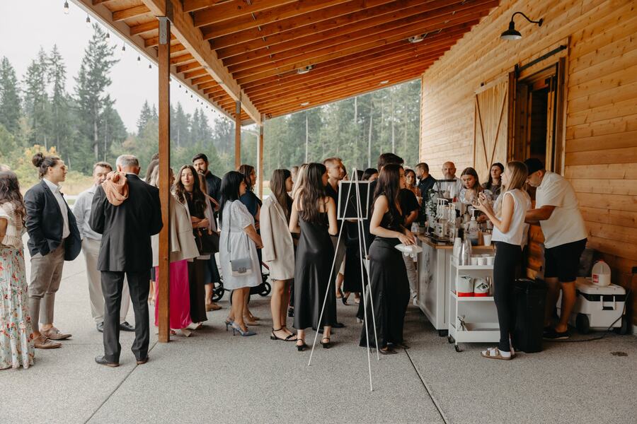 Guests lined up at a coffee cart under the covered patio