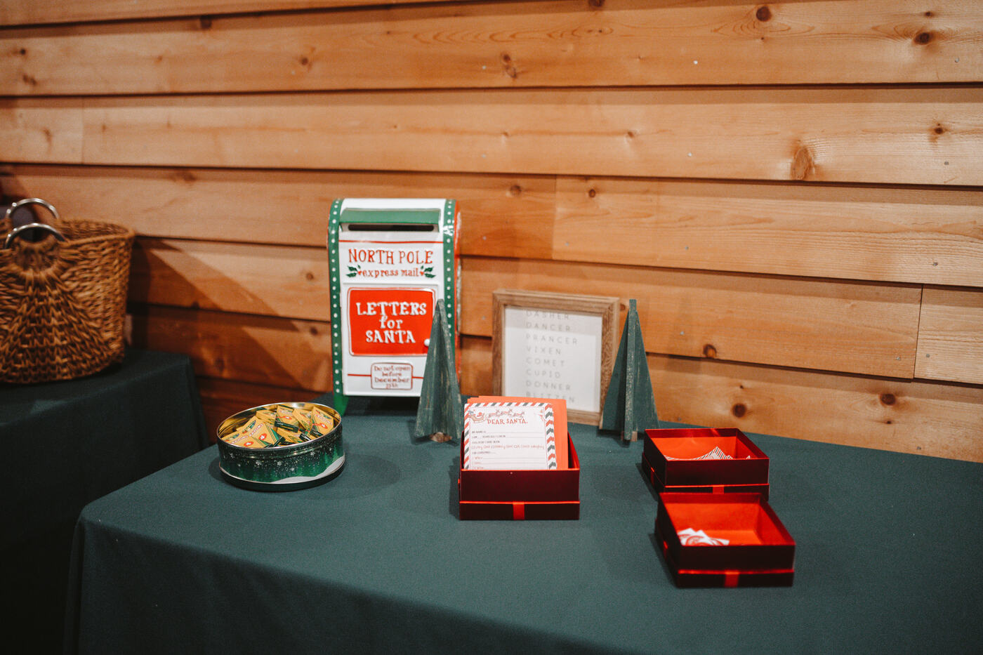 A North Pole mailbox and letters-to-Santa station on a green-draped table