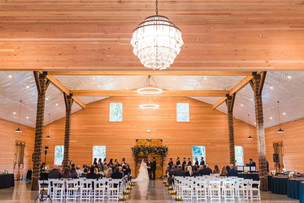 Candlelit ceremony inside the barn under a crystal chandelier