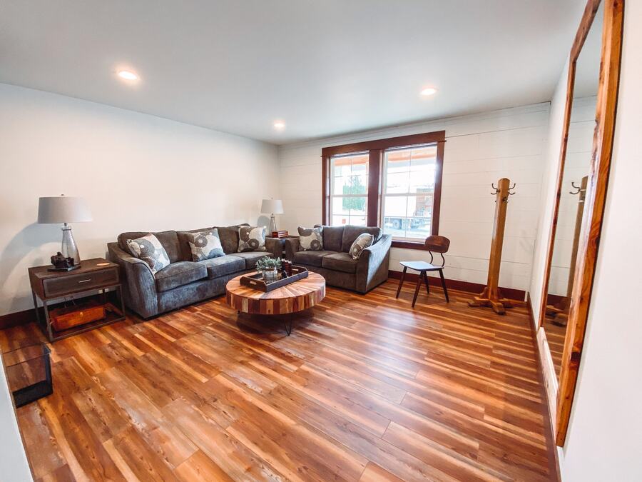 Second getting-ready room with sofas, a round coffee table, and a full-length mirror