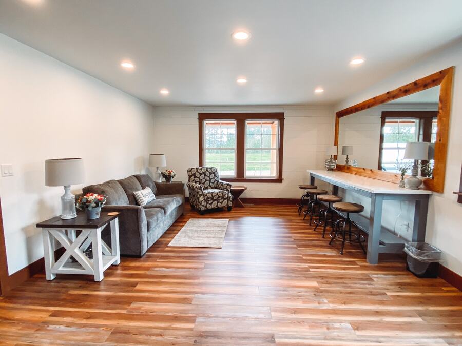 Getting-ready room with a long vanity counter, stools, and a cedar-framed mirror