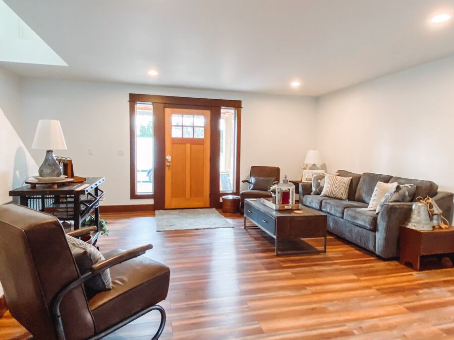 Shared living room with sofas and the cottage's wood front door