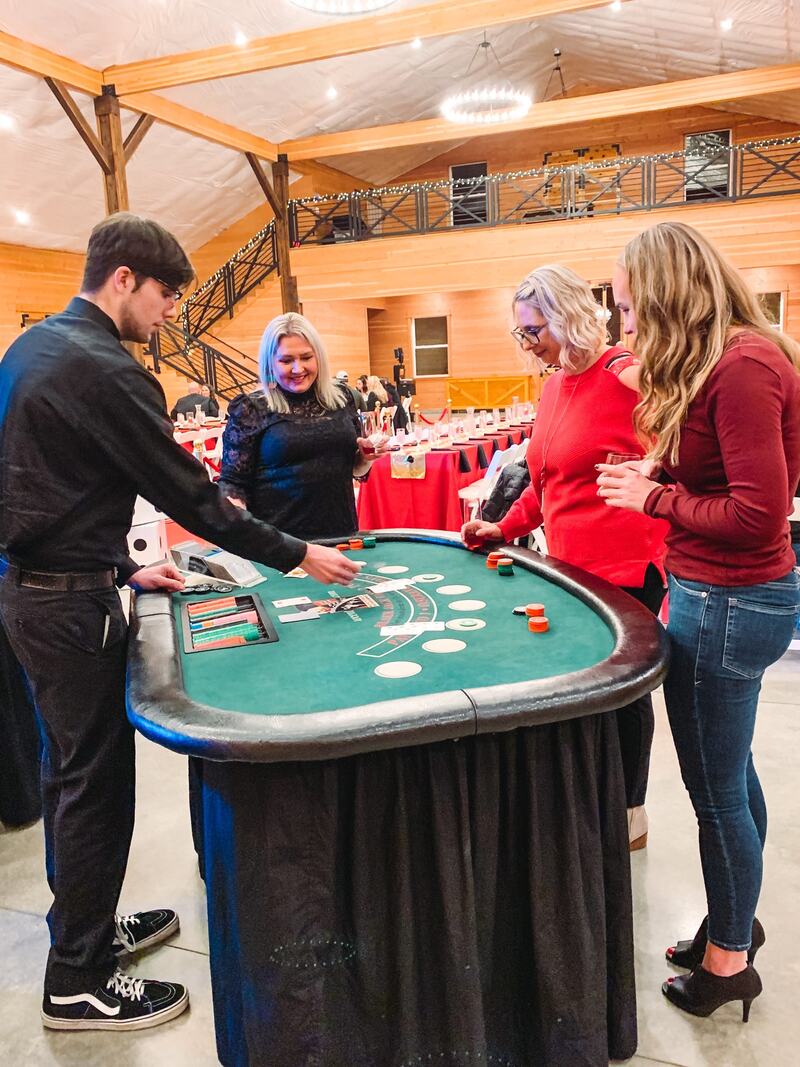 Guests playing blackjack with a dealer, the loft and staircase behind