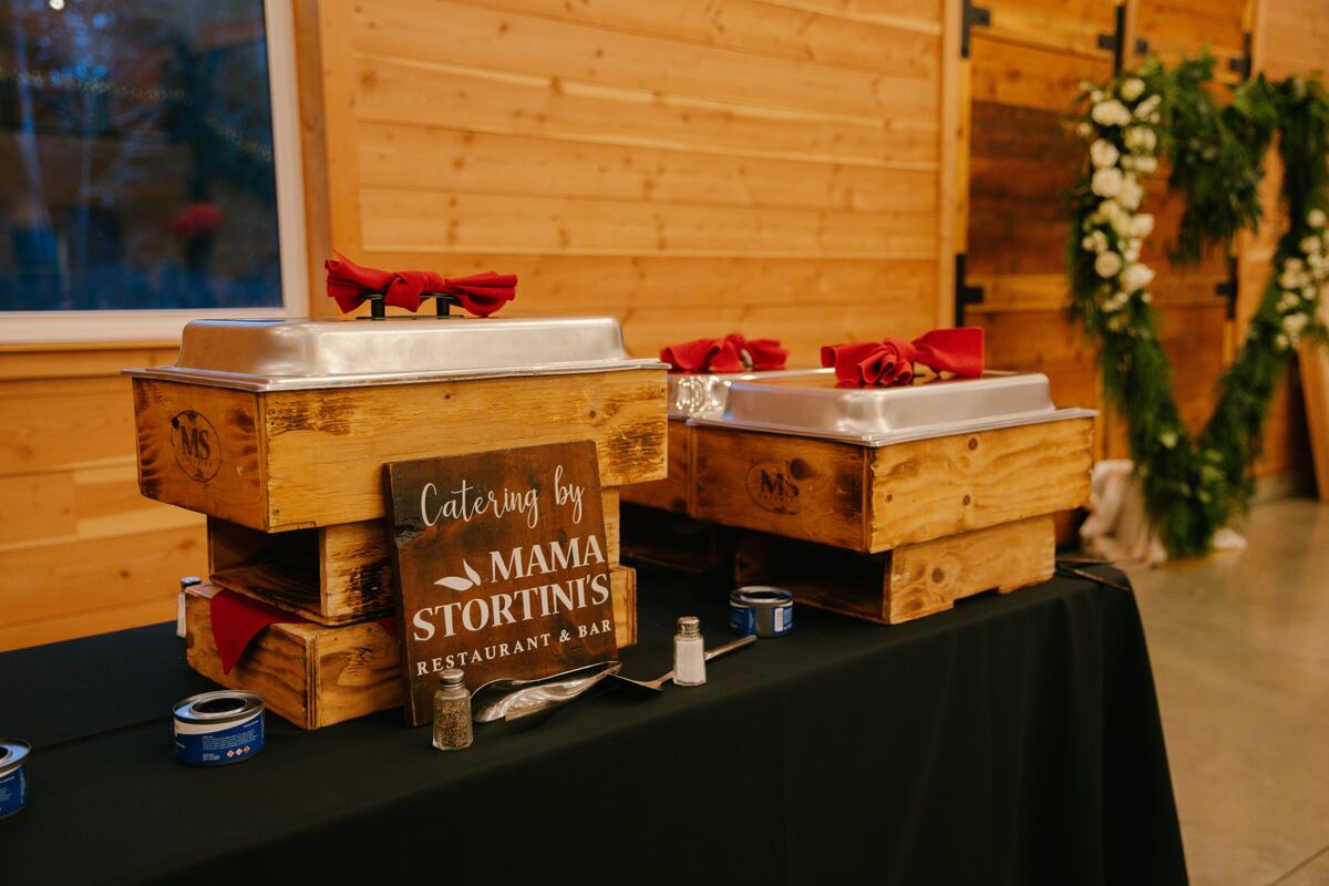 Mama Stortini's catering chafers on wooden stands in the barn
