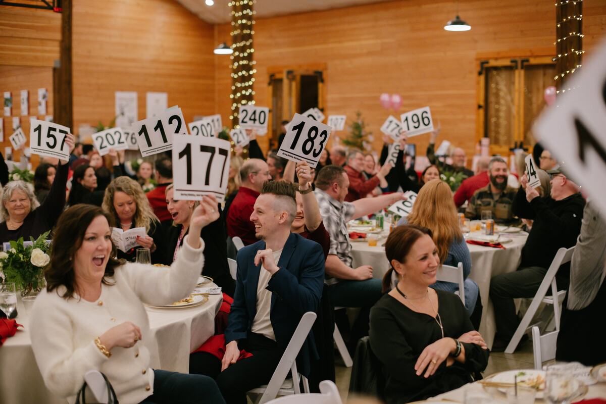 Guests raising bid paddles during the live auction