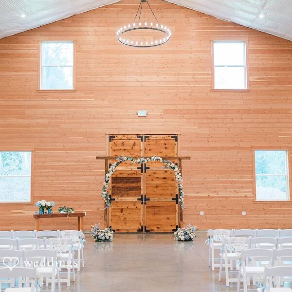 Indoors in the Barn: Ceremony setup with a floral arch