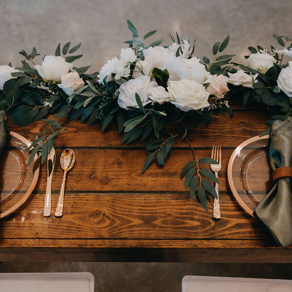Sweetheart farm table with a rose and eucalyptus garland