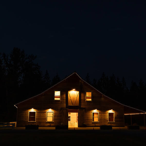The barn glowing at night with doors open