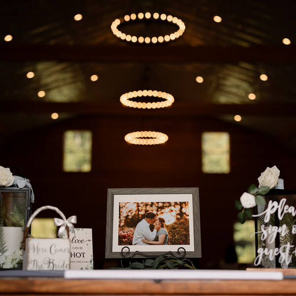 Welcome table with chandeliers glowing behind