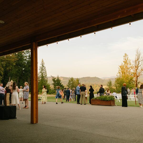 Cocktail hour under the covered patio looking out at the meadow ceremony