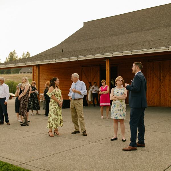 Guests mingling on the patio outside the barn doors
