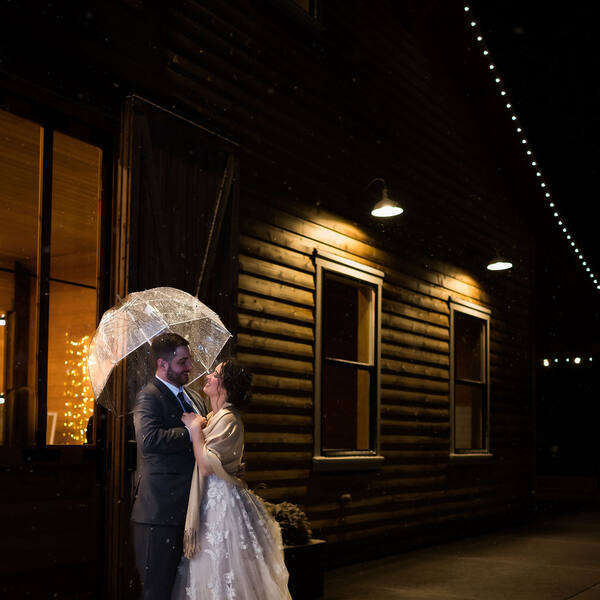 Under an umbrella outside the barn at night