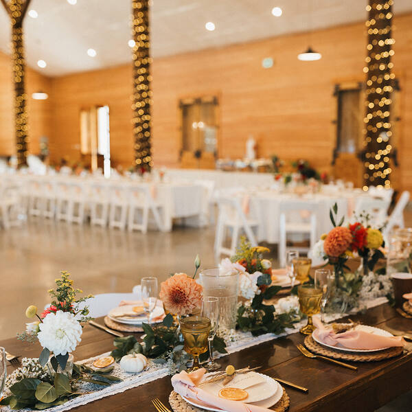 Farm tables under string-lit posts