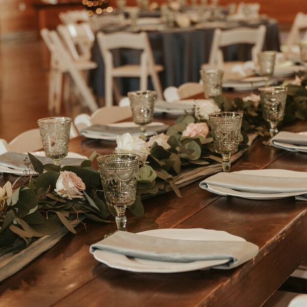 Farm table with rose garland and vintage goblets