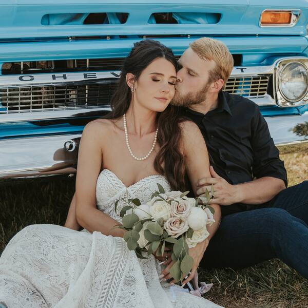 Couple relaxing by a vintage Chevy truck