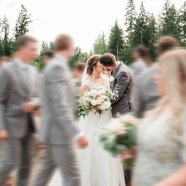 Quiet kiss as the wedding party walks past