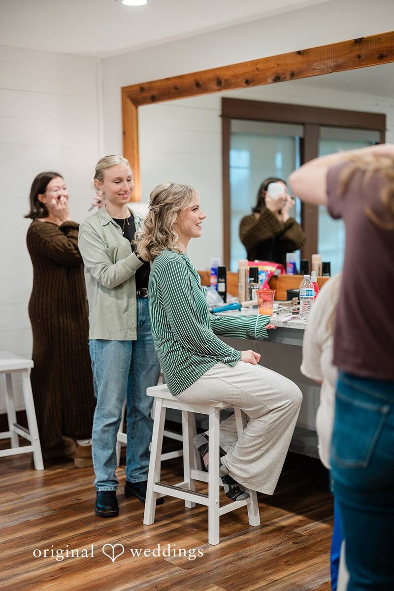 Bride having her hair done at the vanity mirror
