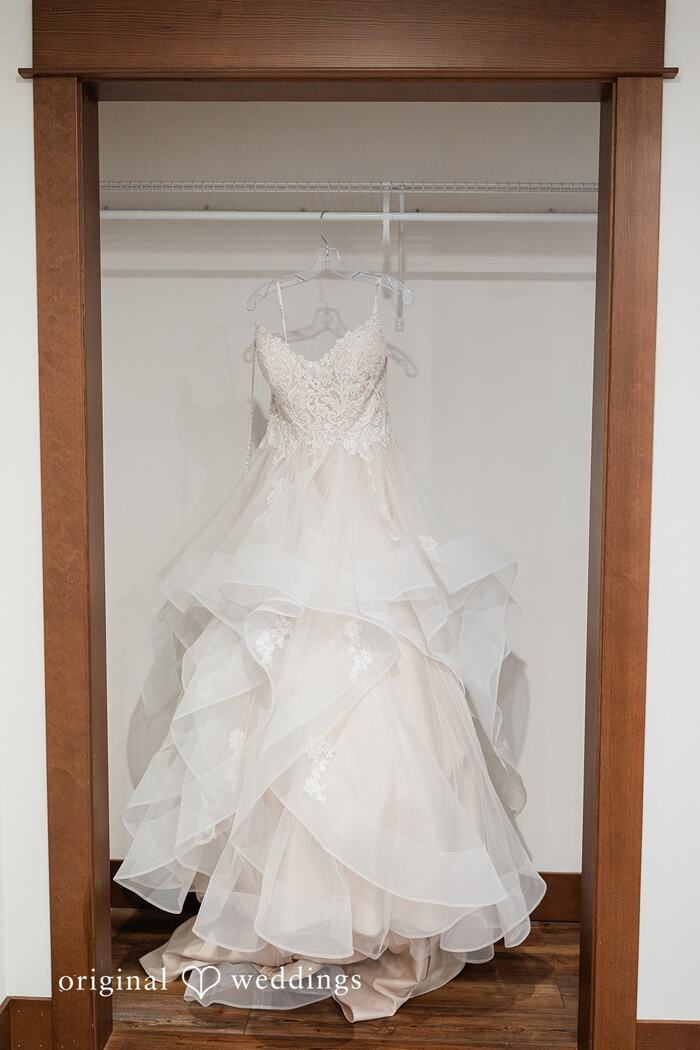 Wedding dress hanging in a wood-trimmed closet