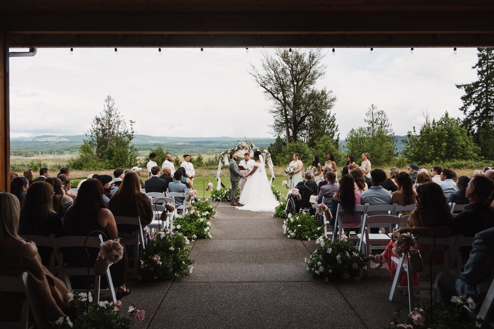 Guests seated in straight rows on the open patio during a ceremony