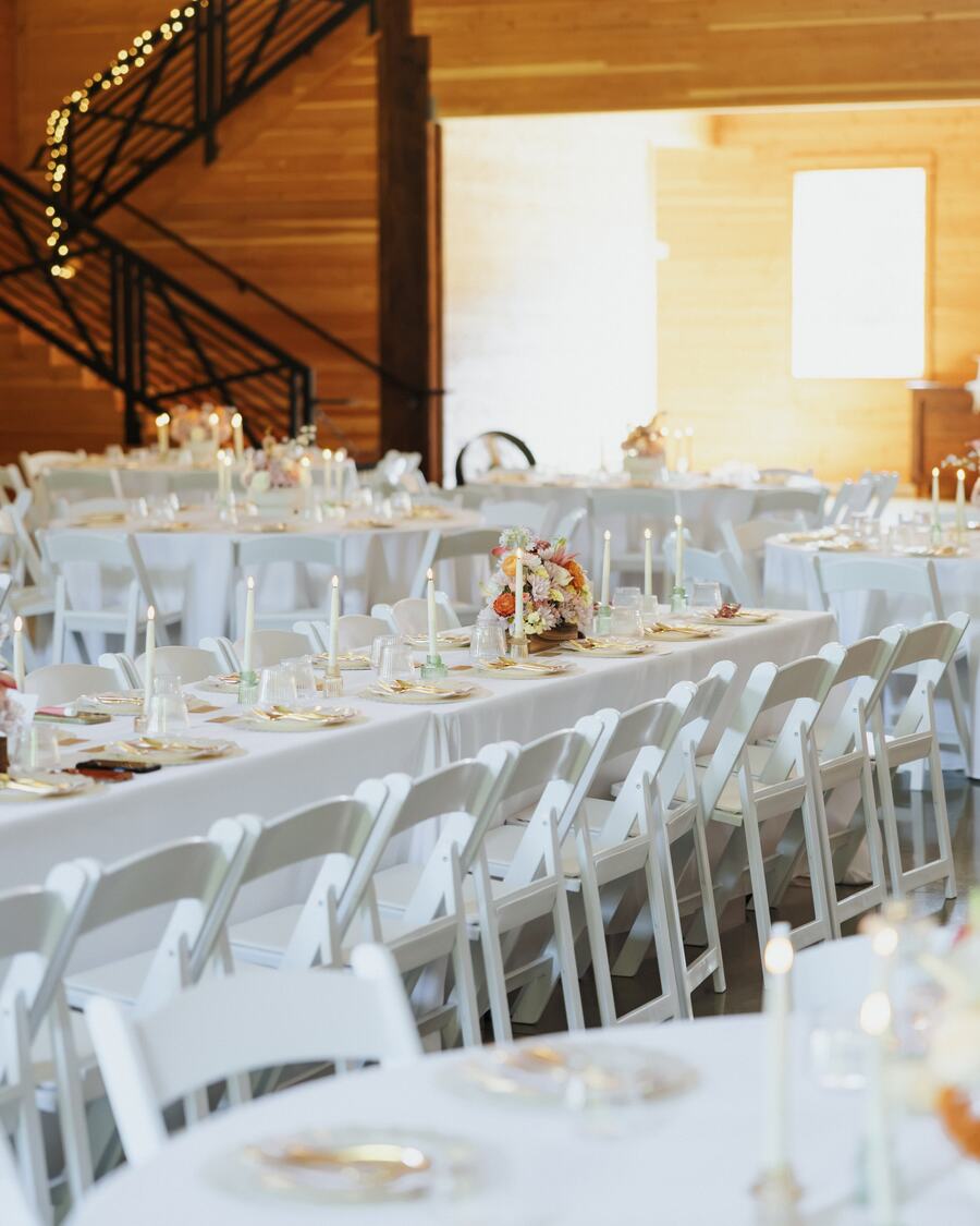 Long candlelit banquet tables beside the black-iron staircase to the loft