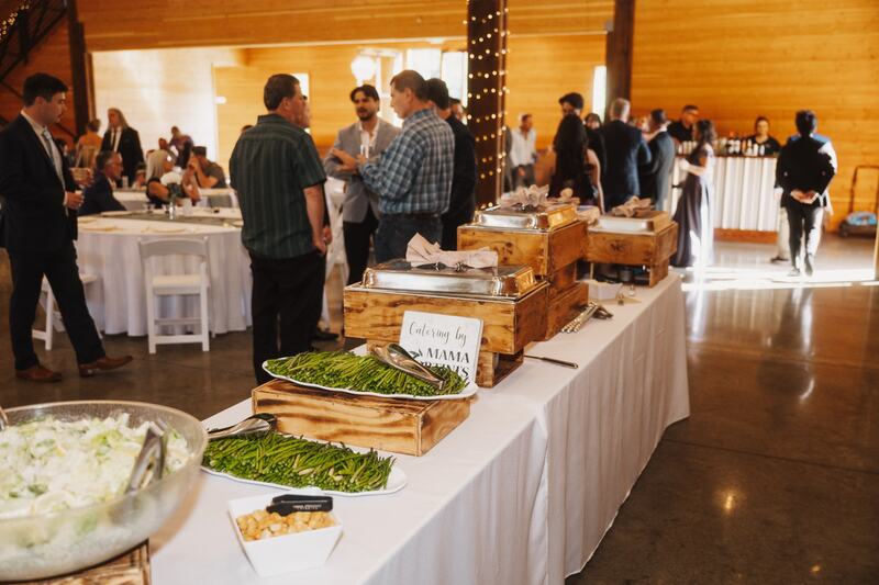 Catered buffet line in the barn with guests mingling